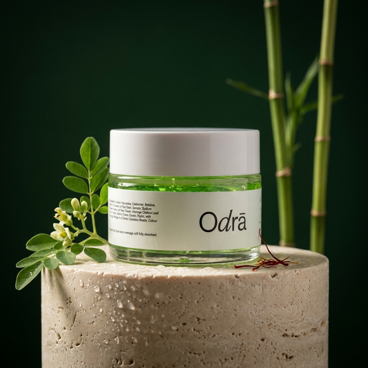 Forest Illume Moisturizer jar on travertine pedestal with moringa leaves and bamboo